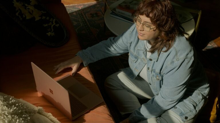 Femme en visioconférence à la table avec un ordinateur portable